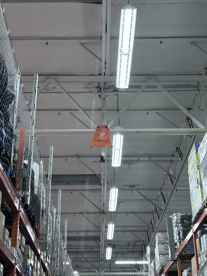 Home Depot apron hanging high from the ceiling structure inside a store aisle