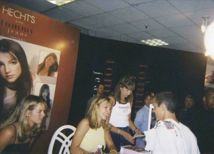 1990s nostalgic event with young people interacting at a Tommy jeans promotional booth, evoking childhood memories.