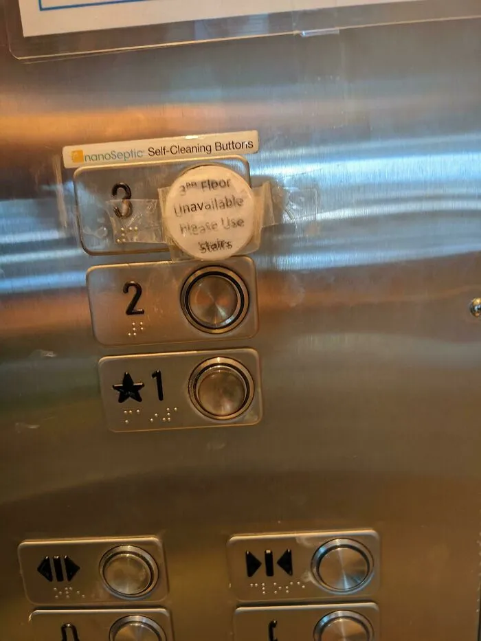 Elevator panel with taped-over 3rd floor button and handwritten sign saying use stairs, a technically works solution.