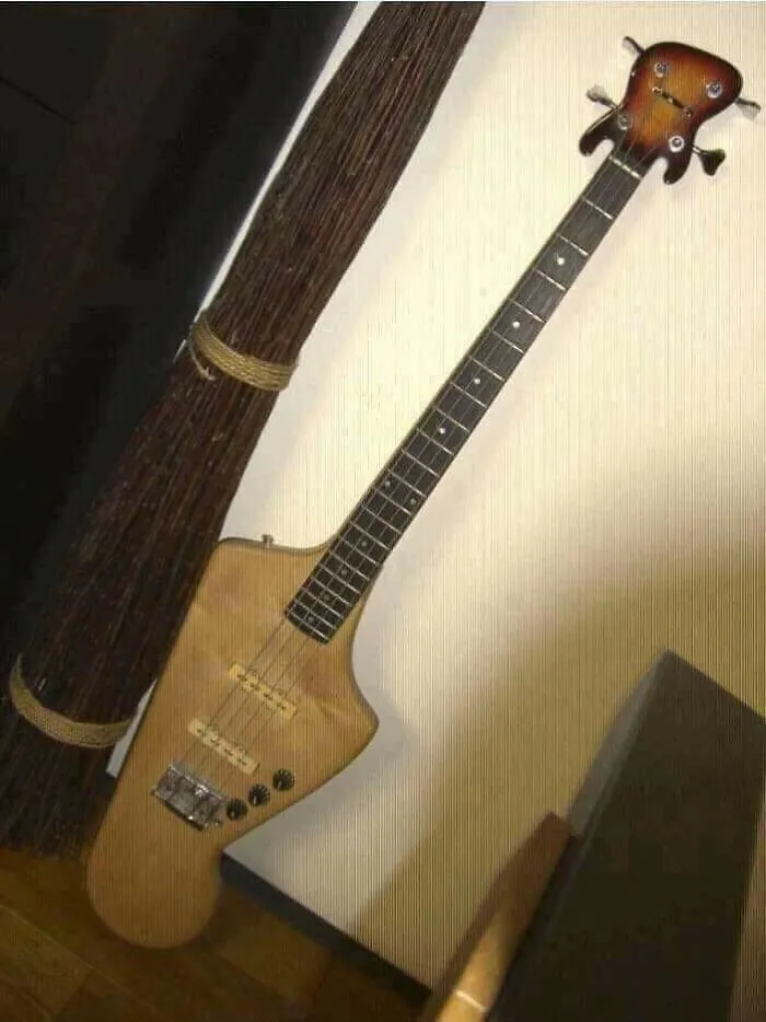 Electric guitar with extremely unusual and flawed craftsmanship design leaning against wall