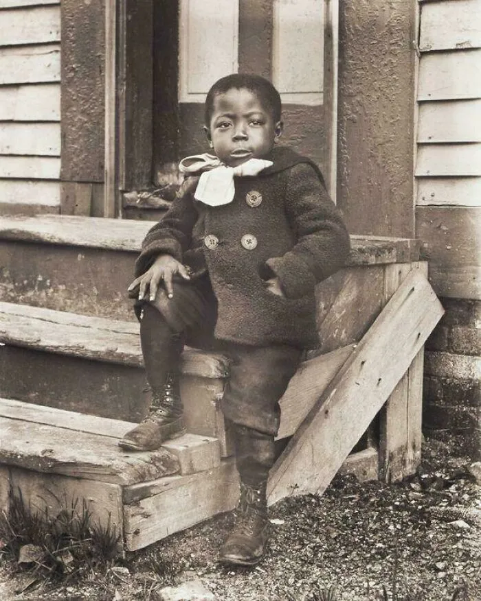 Un niño pequeño posa con orgullo con su abrigo de invierno, alrededor de 1902.