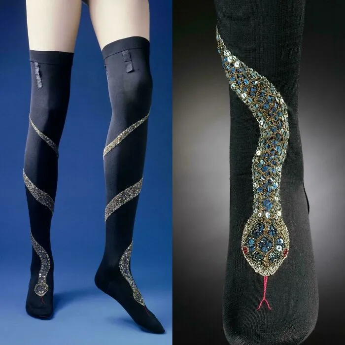 Black vintage stockings with intricate snake-shaped beadwork, a fascinating artefact showcasing historical craftsmanship and design.
