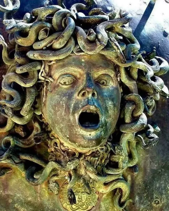 Ancient Medusa artifact showing a detailed bronze head with snakes instead of hair, symbolizing mythology and history.