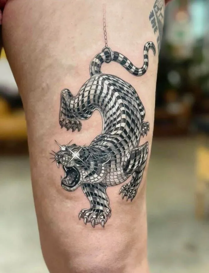 Stunning tattoos: A striking black and white tiger tattoo with a mosaic pattern on a person's leg.