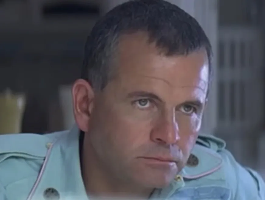 Close-up of a serious man in a uniform, relating to the Alien character Ash from the movie Alien.