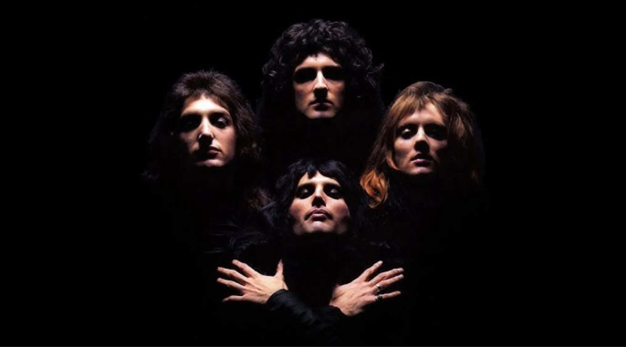 Queen band members in dramatic lighting, iconic image representing 70s pop culture and Bohemian Rhapsody album trivia.