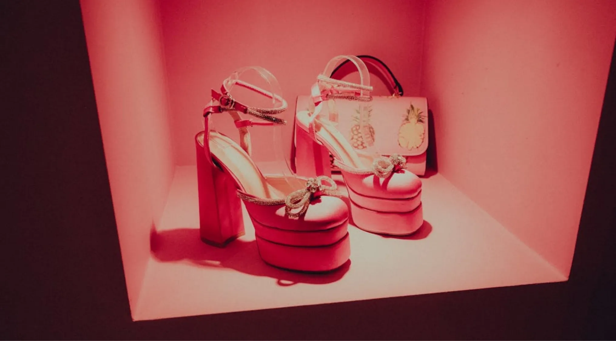 Pink platform shoes with high chunky heels displayed under warm lighting, showcasing 1970s fashion trends.