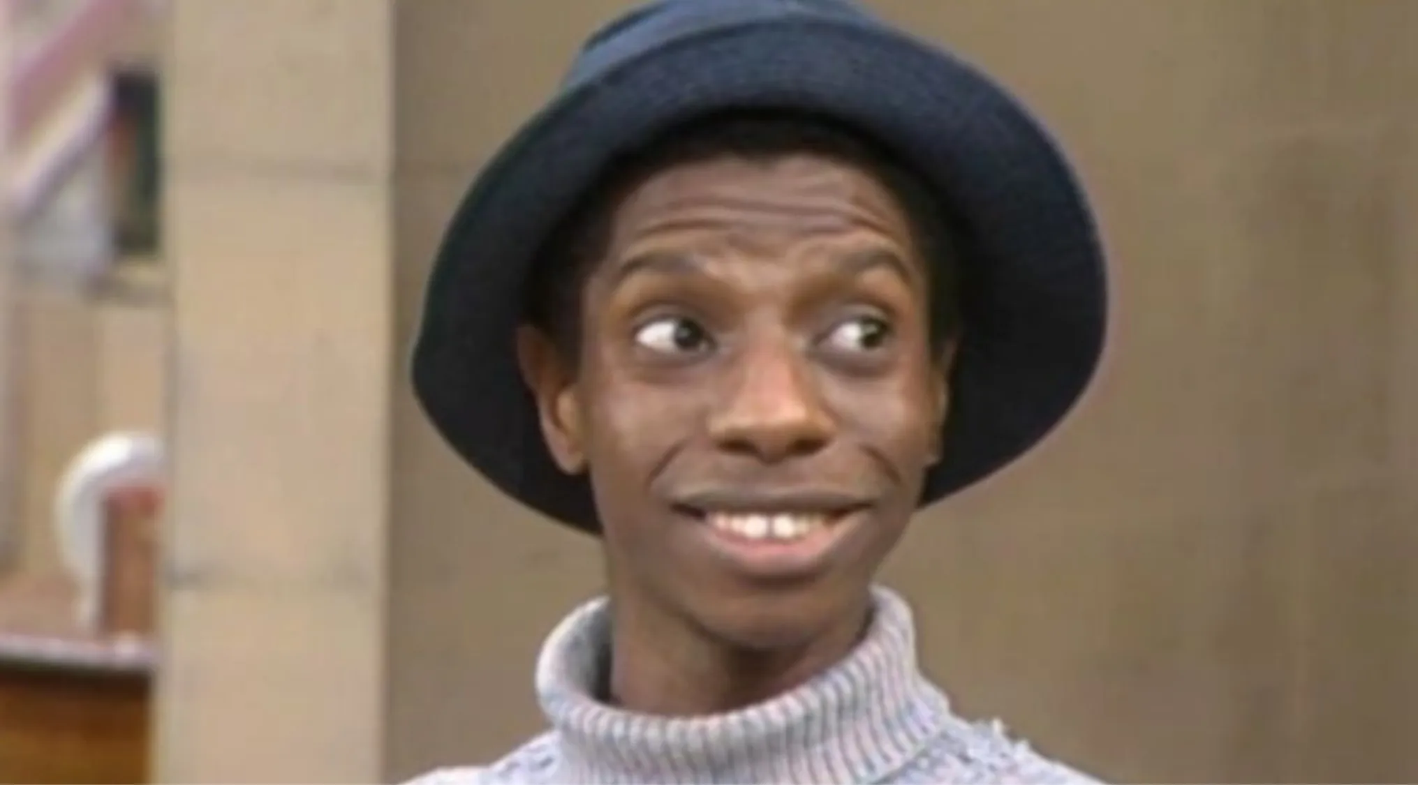 Actor portraying J.J. from Good Times wearing a hat and turtleneck, representing 70s pop culture knowledge quiz.