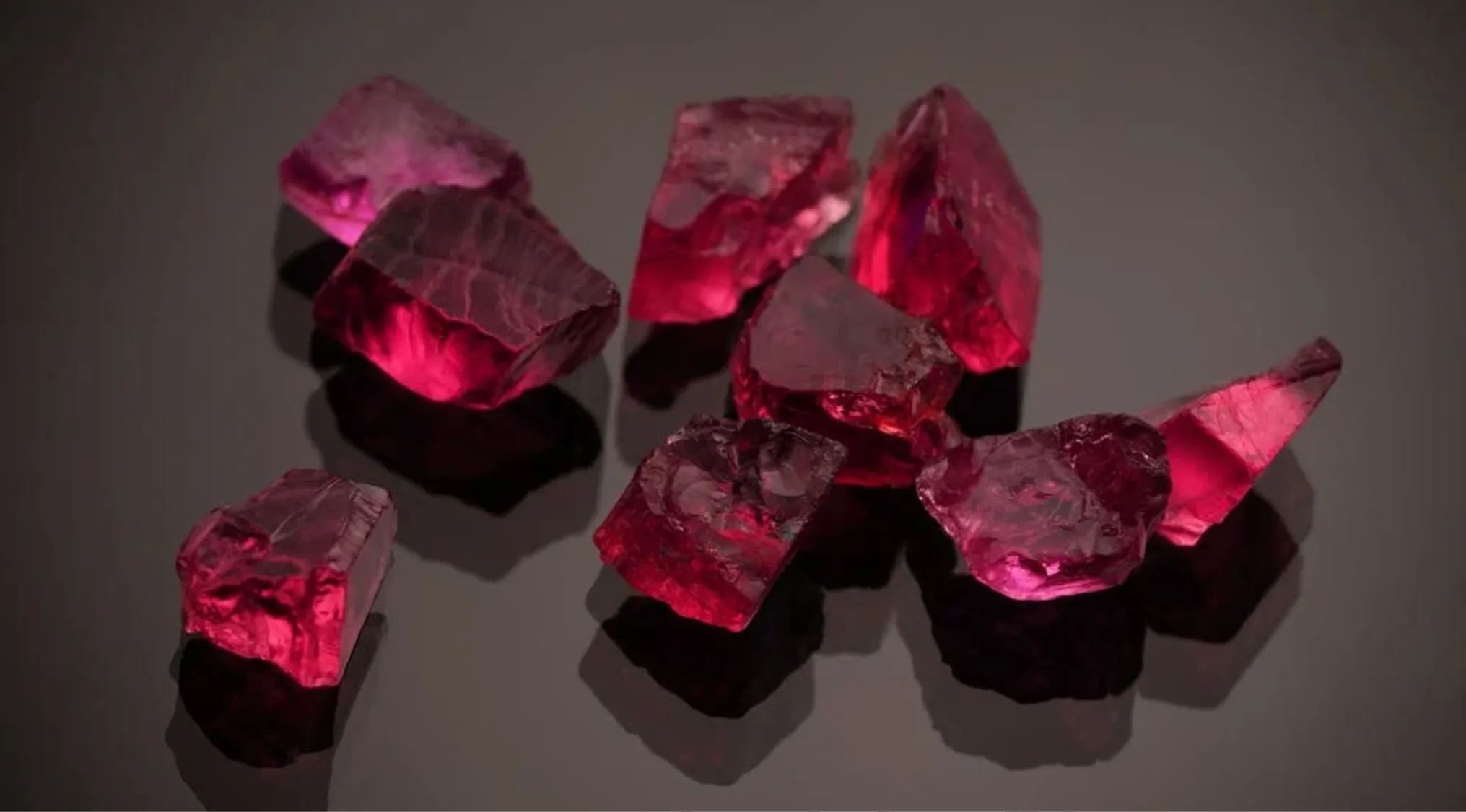 Pinkish red liquid crystals reflecting light on a dark surface, symbolizing 1970s pop culture accessory technology.