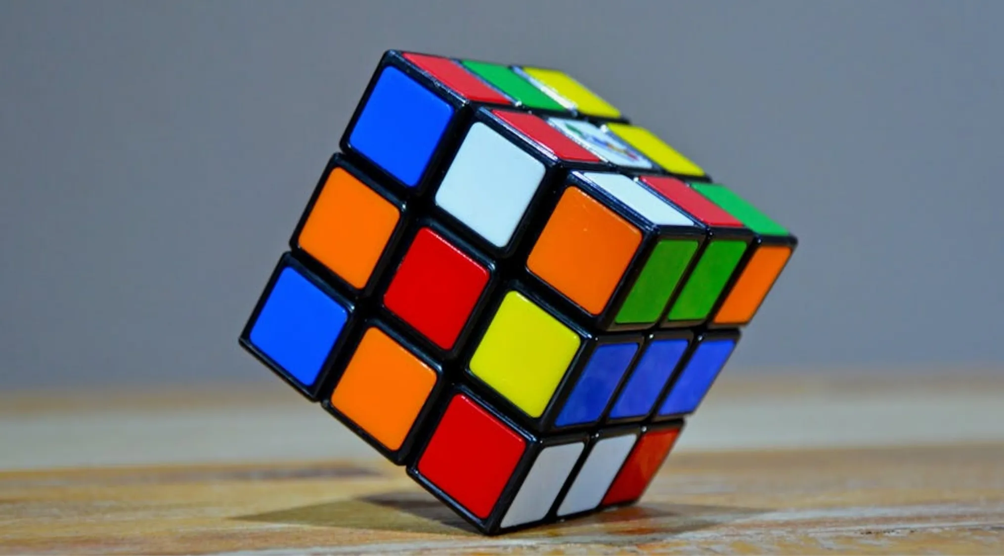 Rubik’s Cube close-up showing colorful squares on a wooden surface, key 70s pop culture puzzle toy from 1974.
