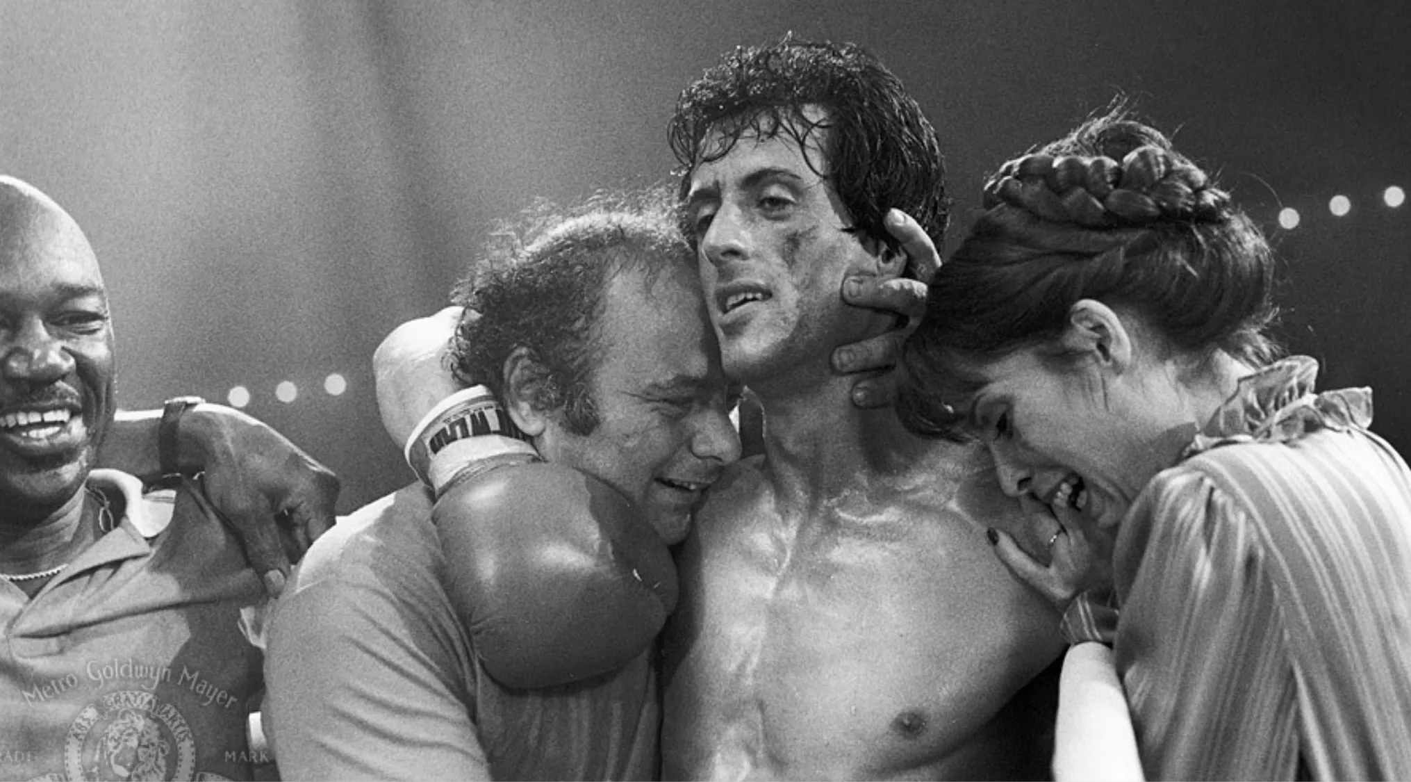 Black and white scene from the 70s pop culture movie Rocky showing an emotional moment after a boxing match.