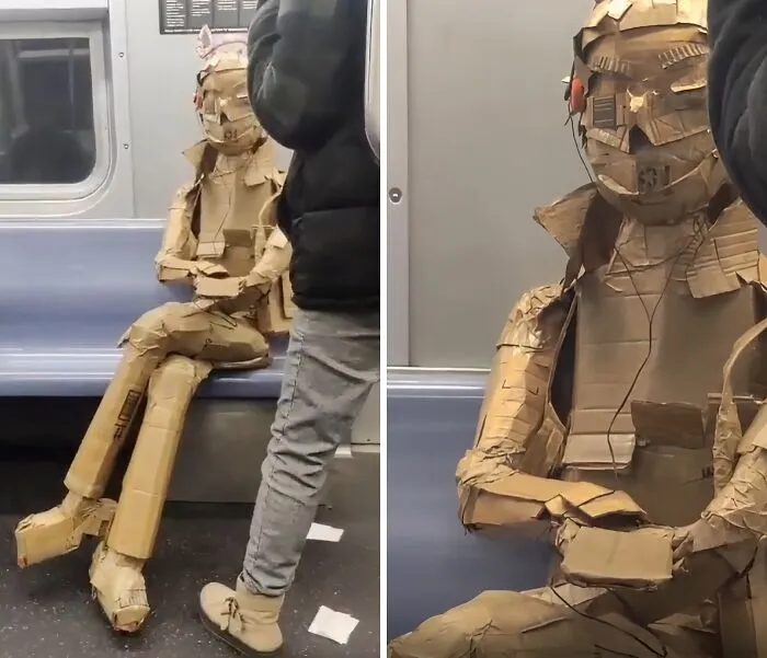 Person wearing a full cardboard costume sitting on a NYC subway bench, showcasing a weird subway moment.