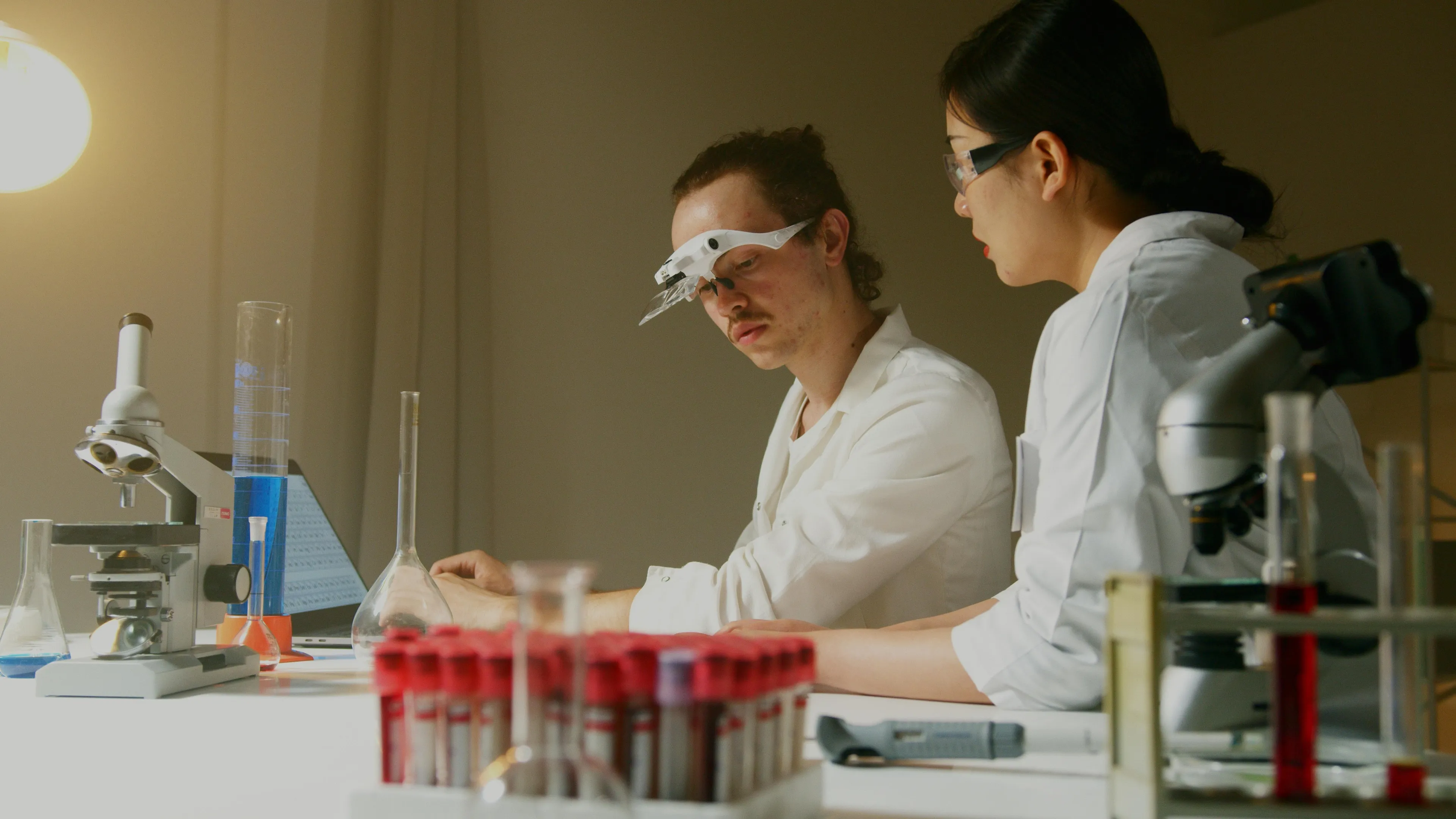 Two scientists in a lab conducting a GCSE Combined Science quiz on compounds formed through ionic bonding.