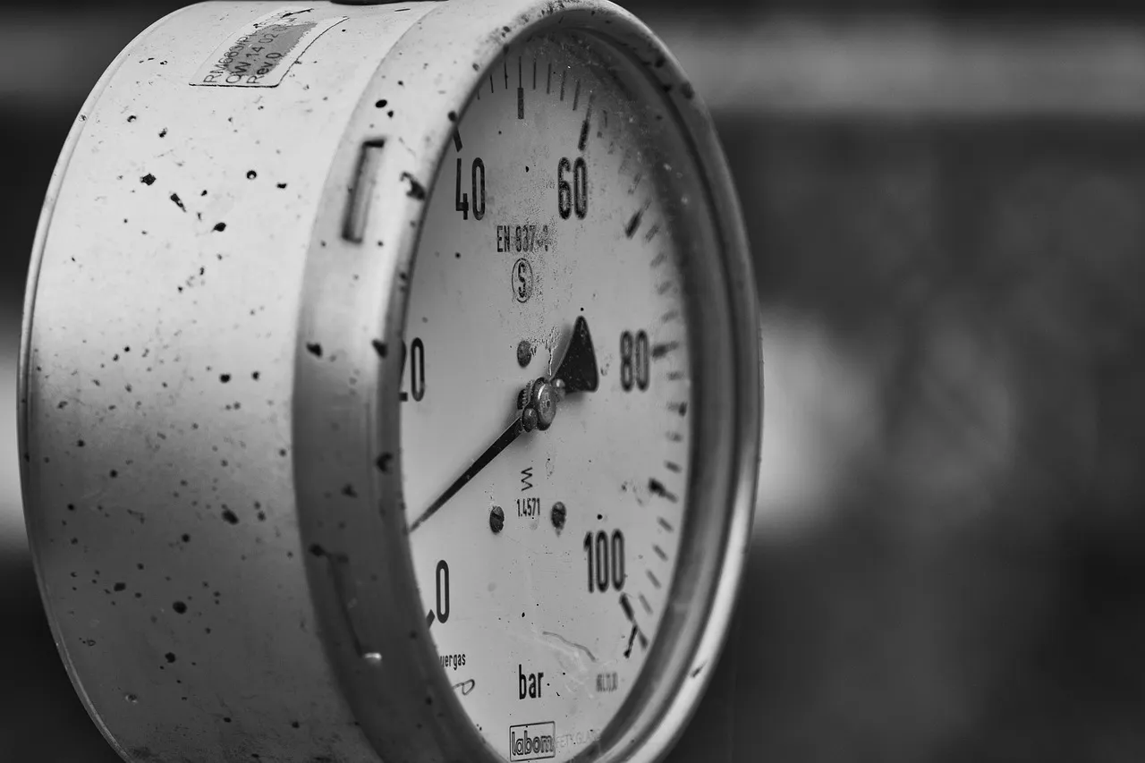 Close-up of a pressure gauge showing pressure levels, illustrating pressure change with increased force and constant area.