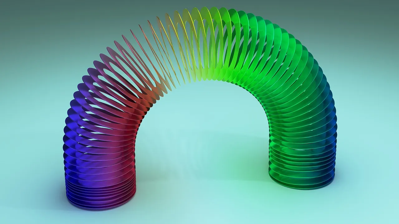 Colorful stretched spring toy forming an arch, illustrating energy stored in a stretched spring for GCSE combined science quiz.