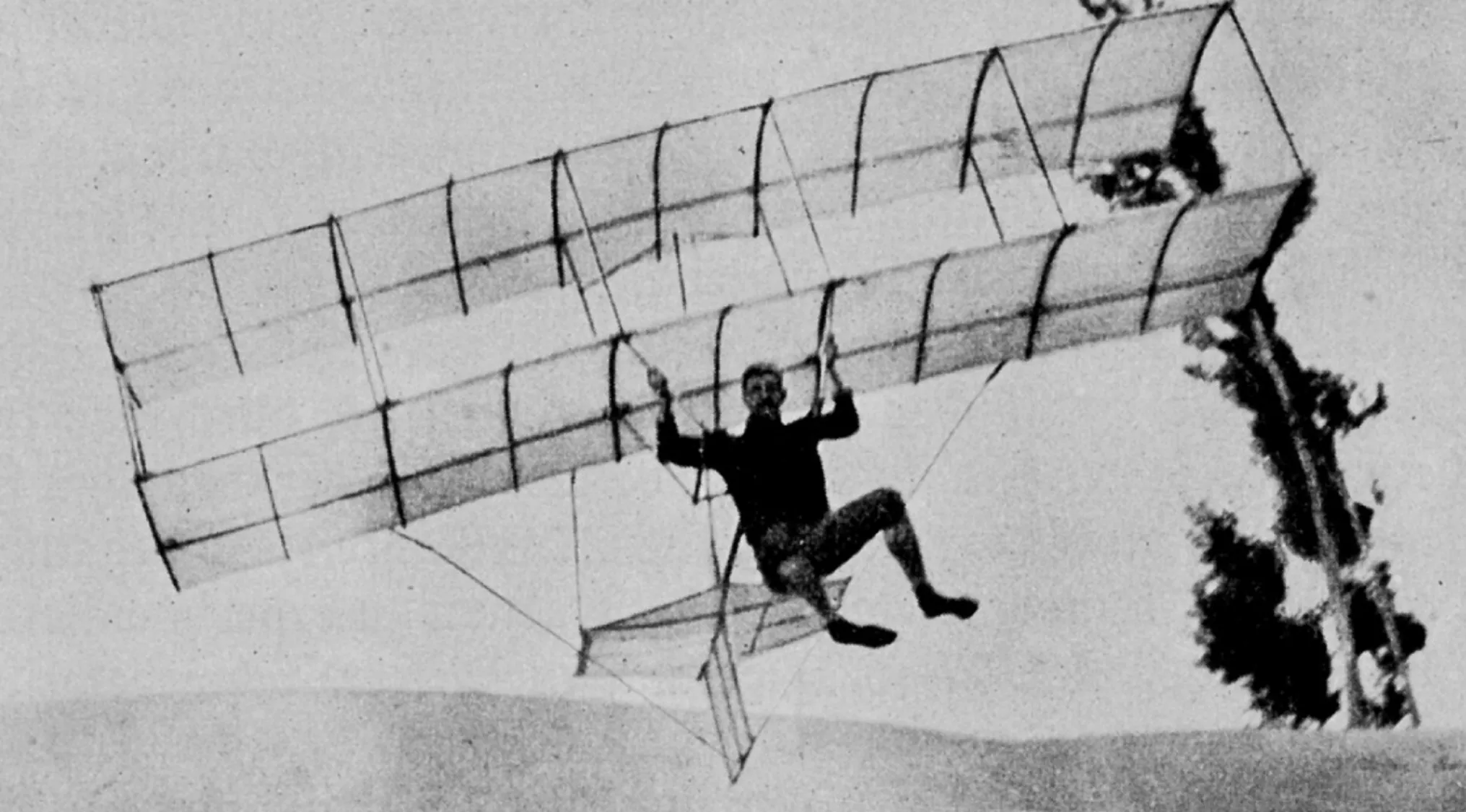 Early Wright brothers airplane in flight during the 1900s first controlled sustained flight era.