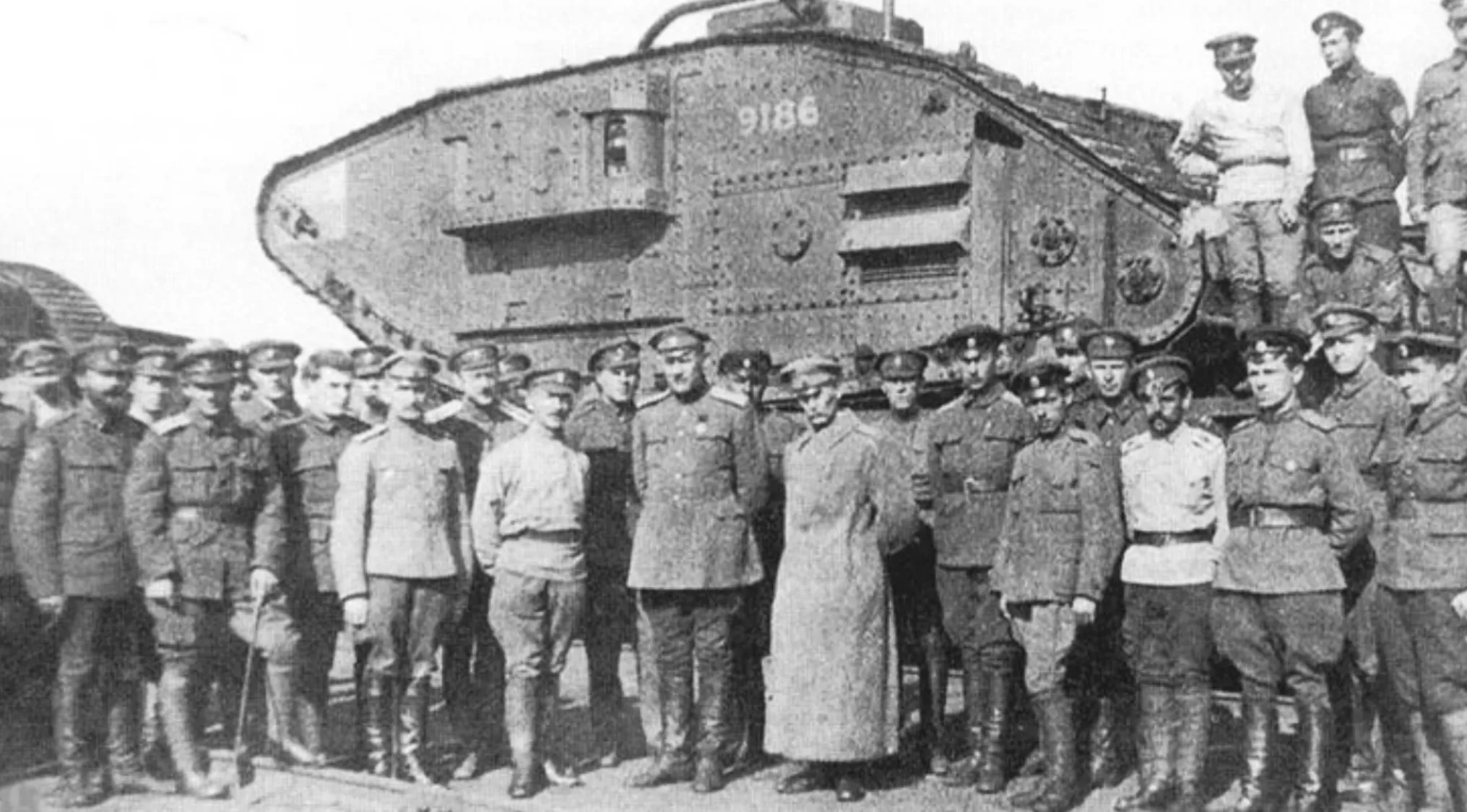 Group of soldiers posing with a large WWI tank, related to the year the Soviet Union was established.