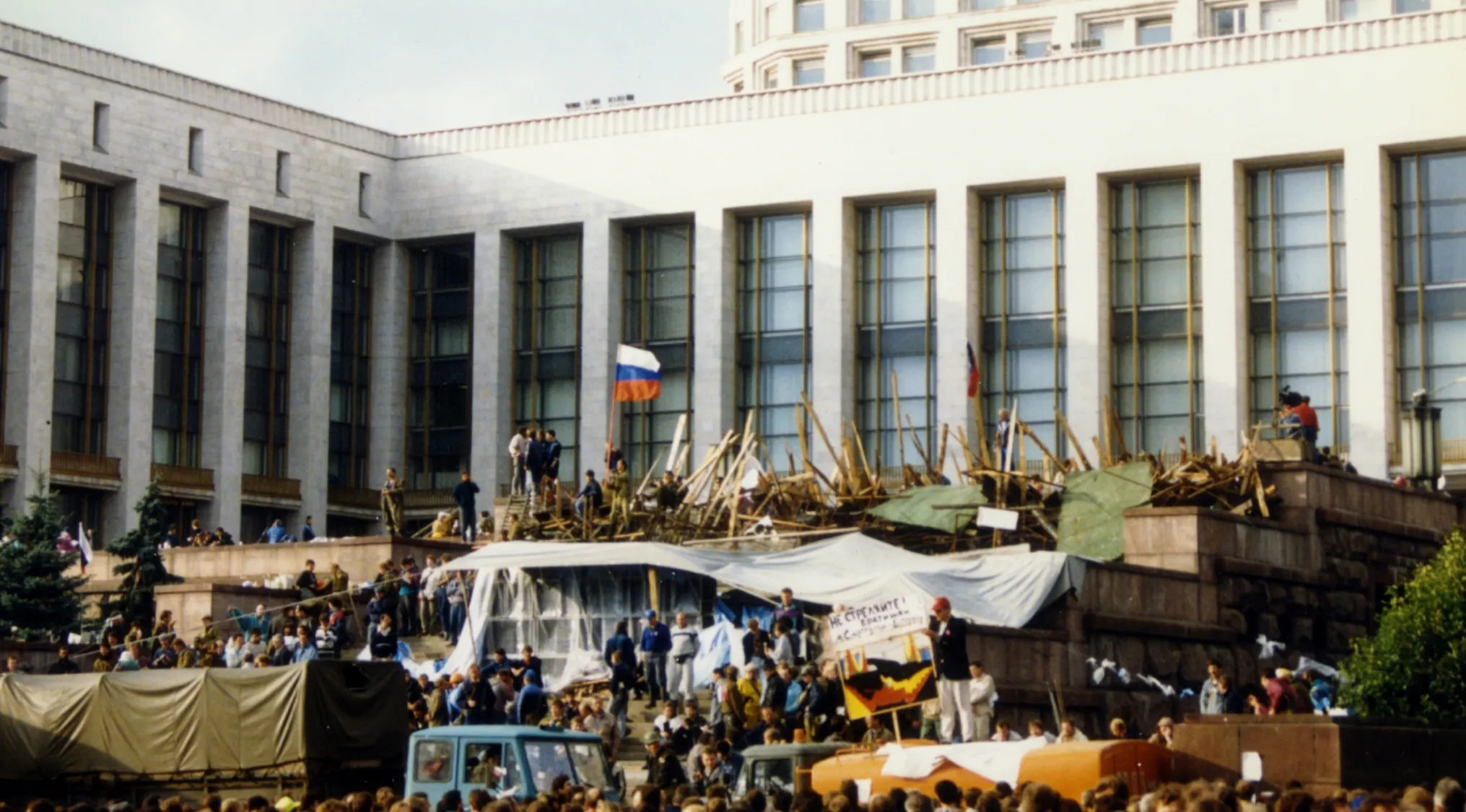 Crowd gathered outside government building near barricades during the dissolution of the Soviet Union in 1991.