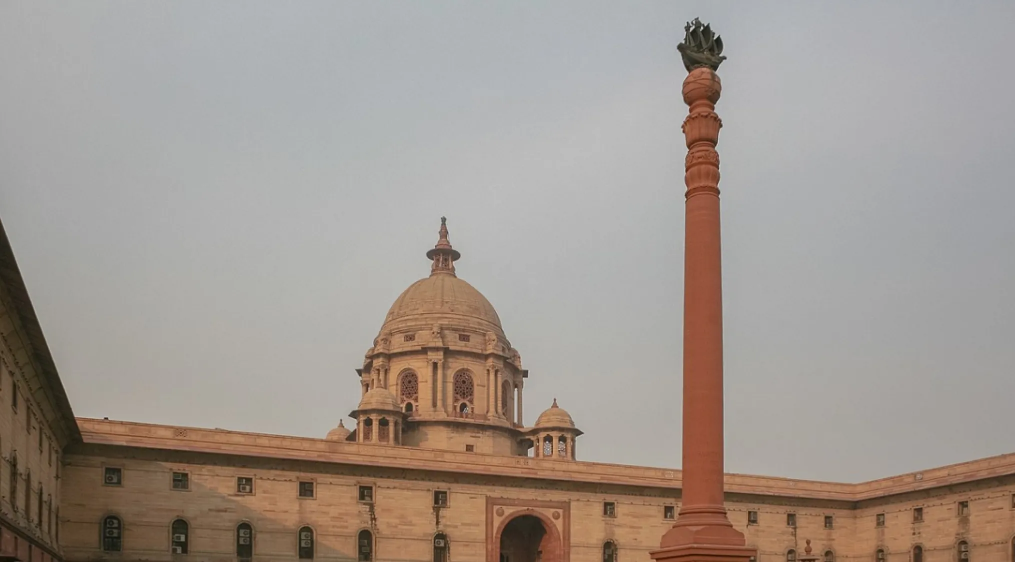 Historic government building in India with a tall pillar symbolizing the era India became independent in the 19__s.