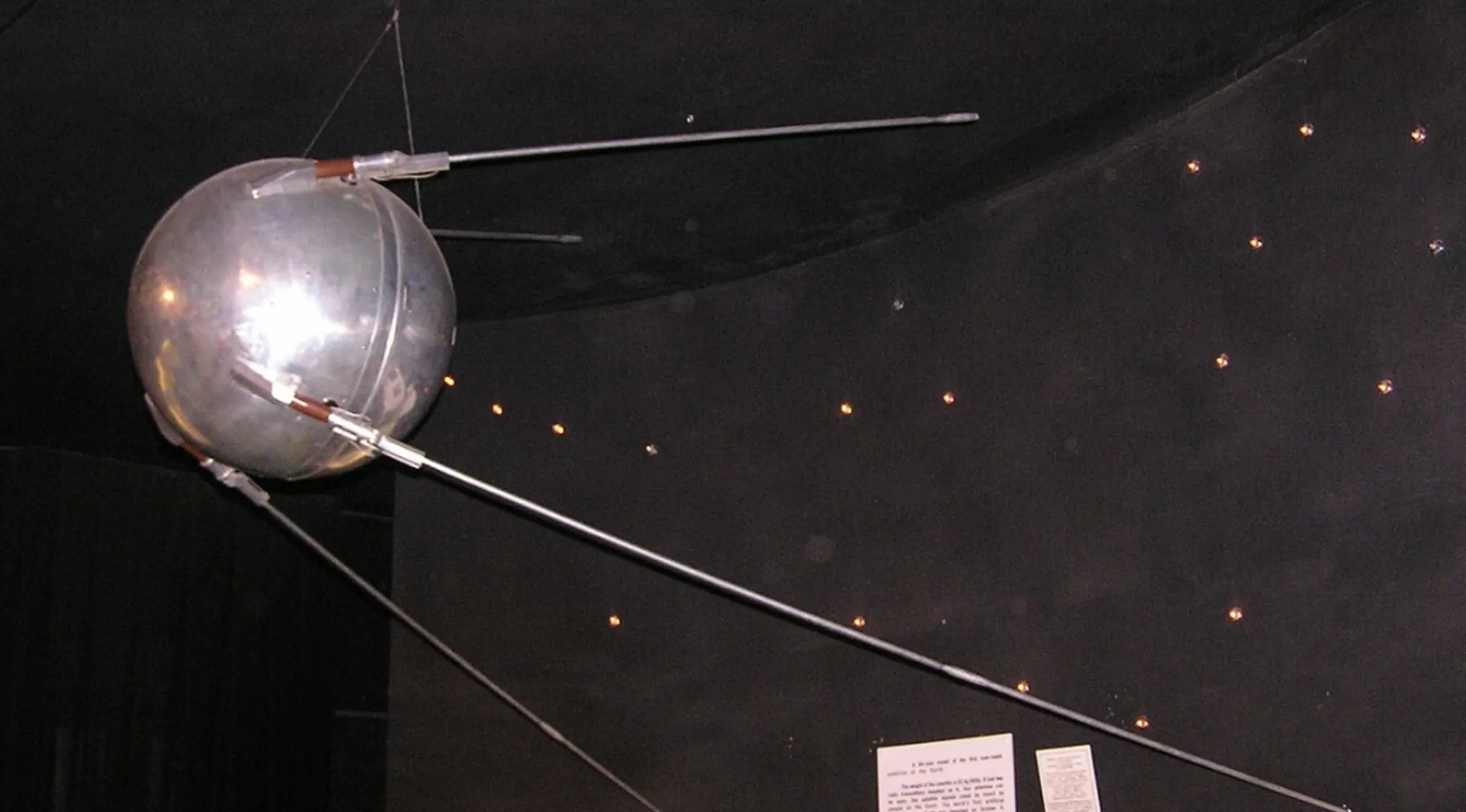 Sputnik 1 model displayed in a museum exhibit representing the first artificial satellite launched in the 1950s.