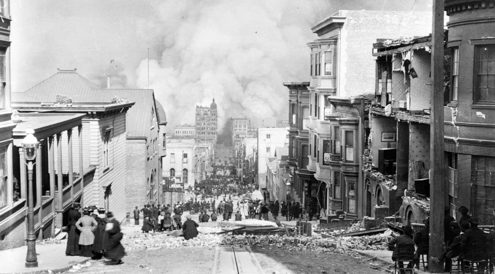 San Francisco street damaged by major earthquake with collapsed buildings and smoke rising in the 1900s.
