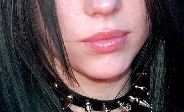 Close-up of a celebrity’s mouth with glossy lips and black hair, part of a guess the celebrity mouth challenge.