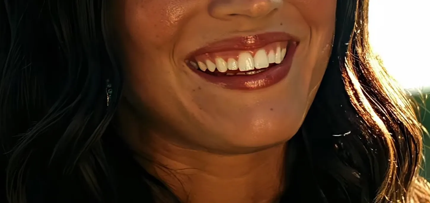 Close-up of a smiling mouth with glossy lipstick for a guess the celebrity from their mouth challenge.