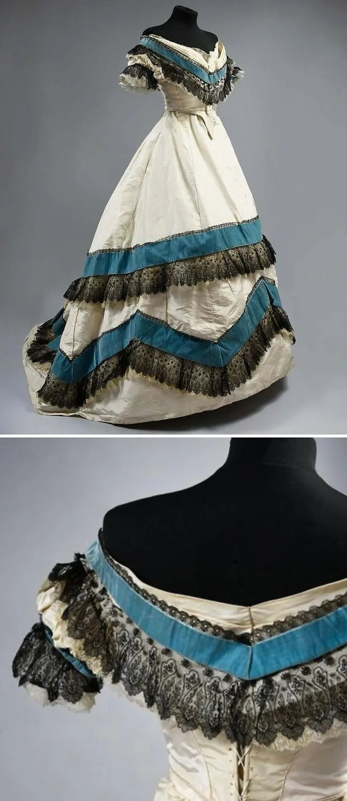 Victorian historical garment with blue and black lace details on cream fabric, displayed on a black mannequin.