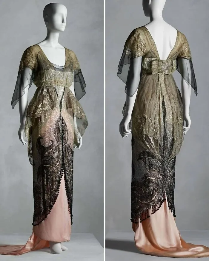 Mannequin wearing an ornate historical garment with black and gold lace overlay and a long pink satin skirt.
