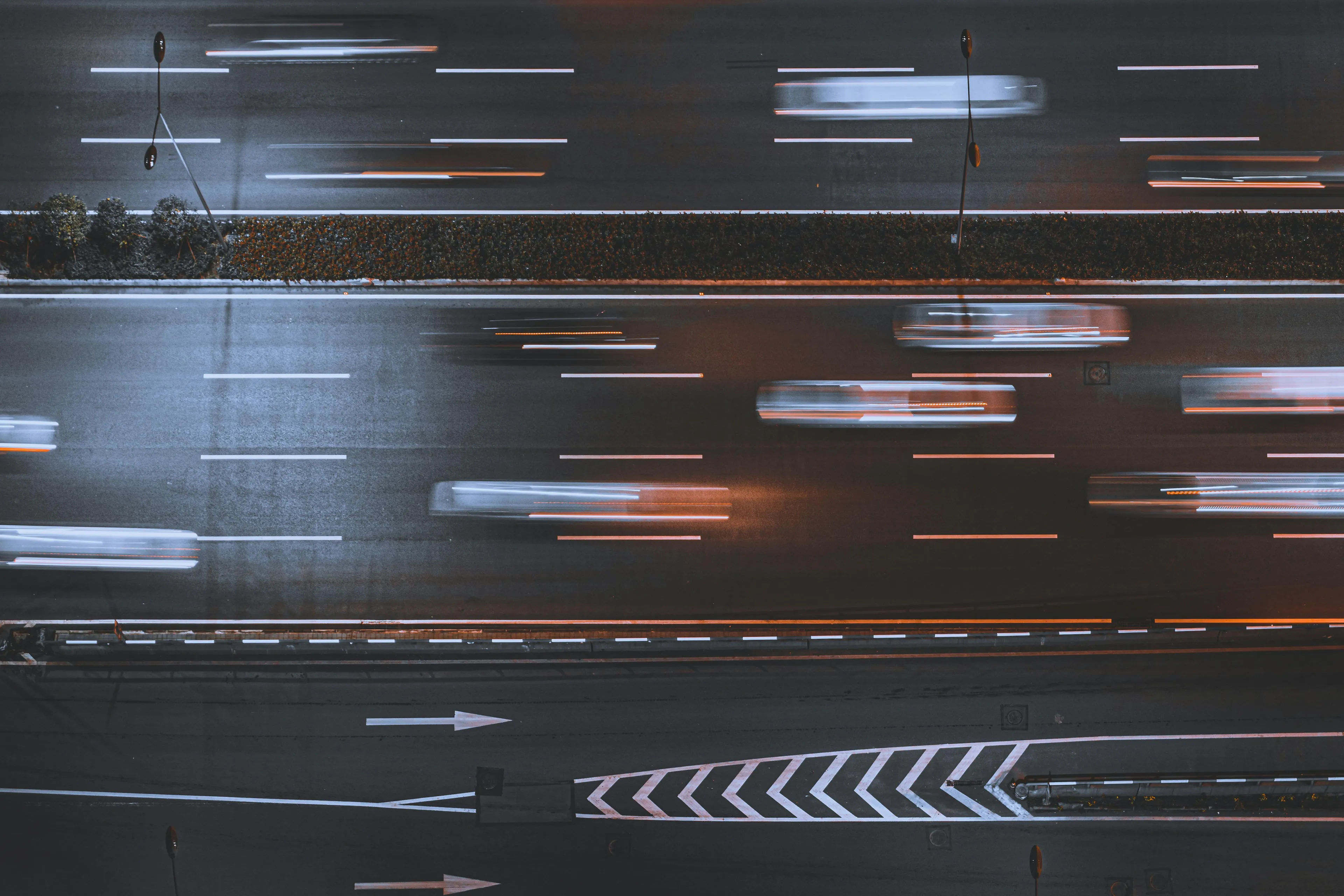 Blurred cars moving on a multi-lane road at night illustrating the physics concept of velocity including direction versus speed.