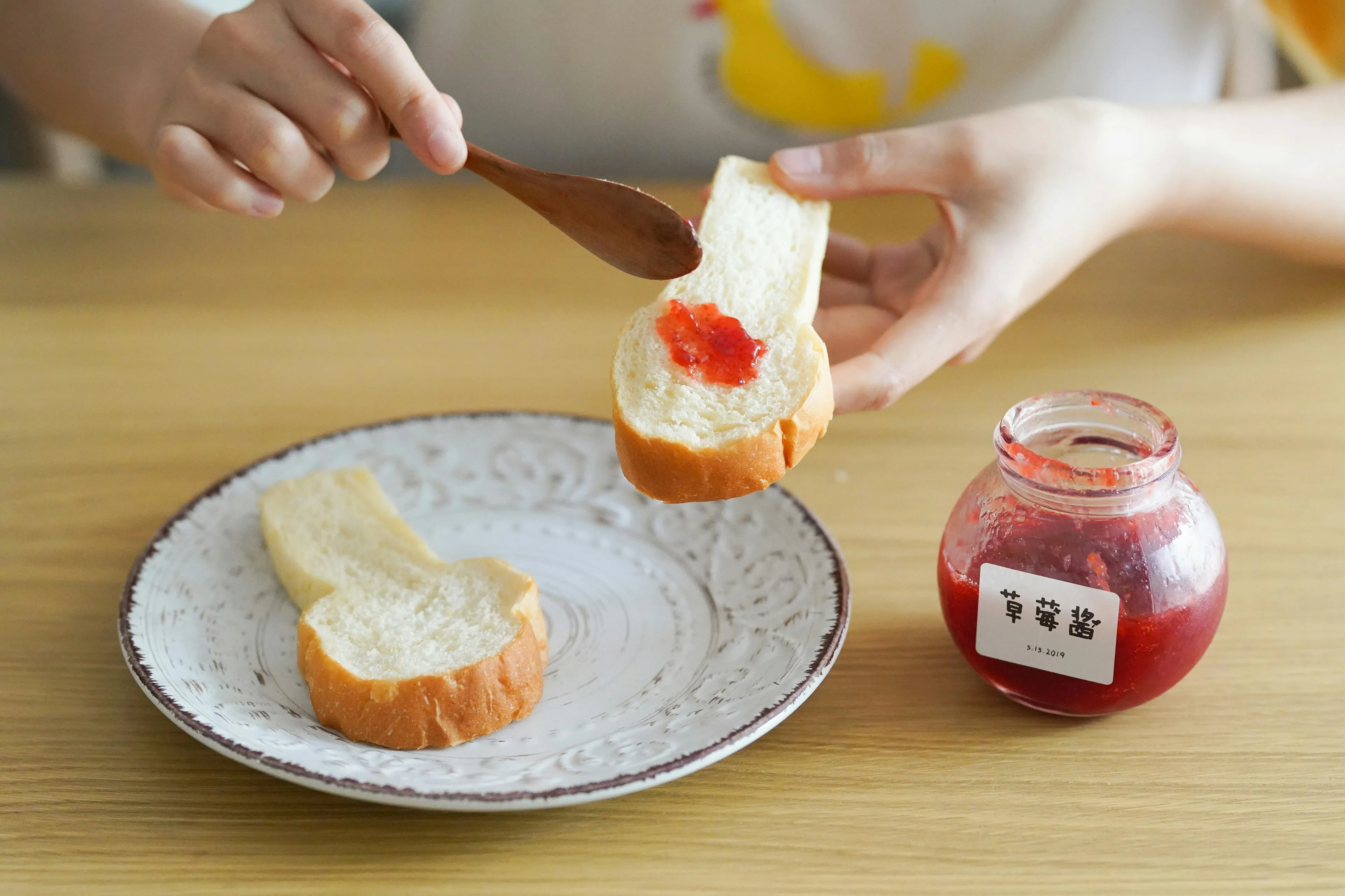 Person spreading red jam on a slice of bread beside a jar of strawberry jam showing differences general knowledge quiz.