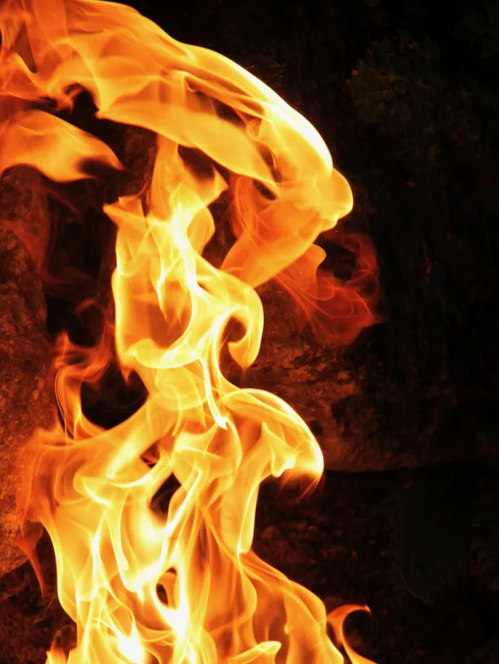 Bright orange and yellow flames dancing against a dark background, illustrating fiery mysteries and intrigue.