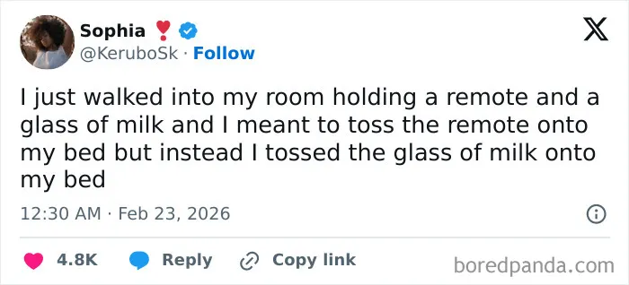Tweet showing a humorous February post about accidentally tossing a glass of milk instead of a remote onto a bed.