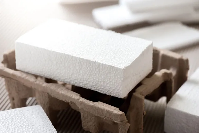 Close-up of a styrofoam block in a brown tray, highlighting healthcare workers' concerns about single-use materials.