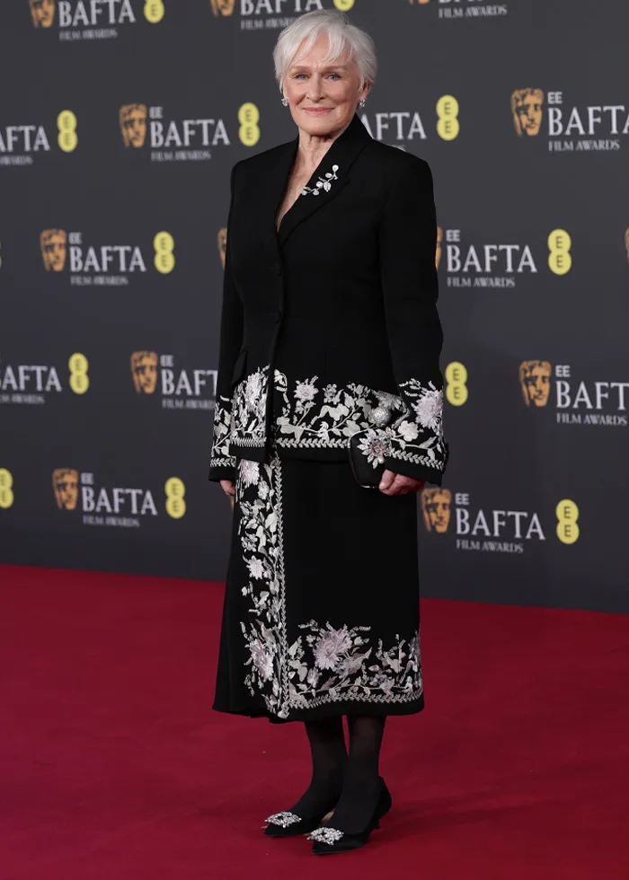 Elegant woman on the red carpet wearing a black outfit with floral embroidery at the most talked-about BAFTA 2026 red carpet outfits.