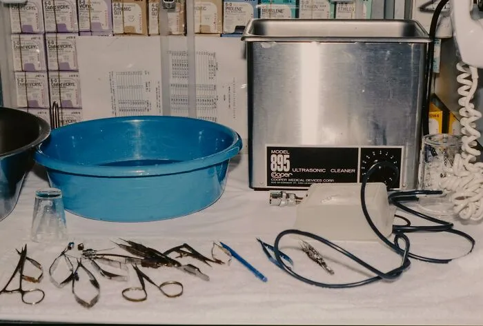 Surgical tools and ultrasonic cleaner on a medical table, related to autopsy findings and strange medical discoveries.