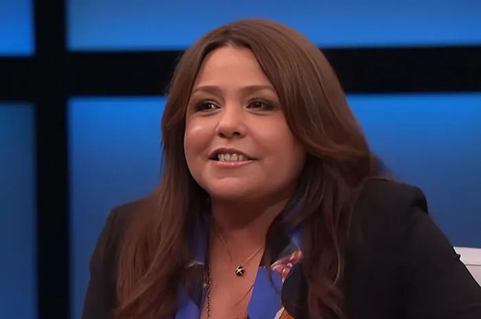 Woman with long brown hair smiling during a TV interview about Beyoncé and celebrities who lost fans.