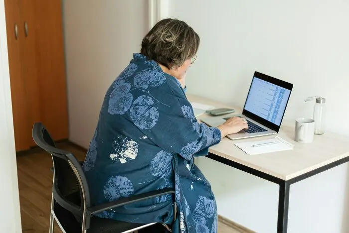 Person working on a laptop at a desk, highlighting dangerous things often dismissed in everyday situations.