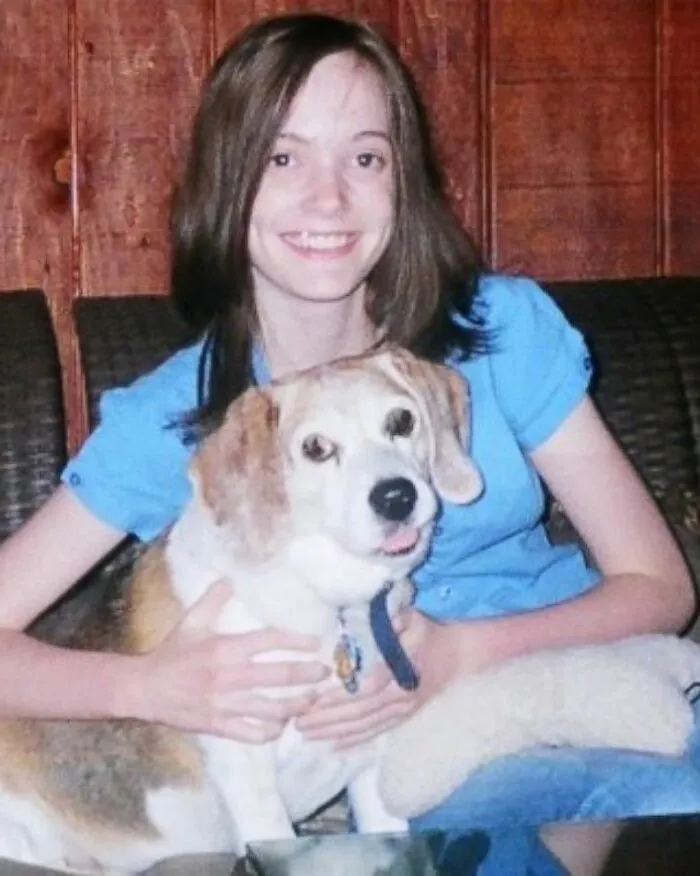 Young woman smiling and hugging a dog, illustrating unusual autopsy findings that left doctors speechless.