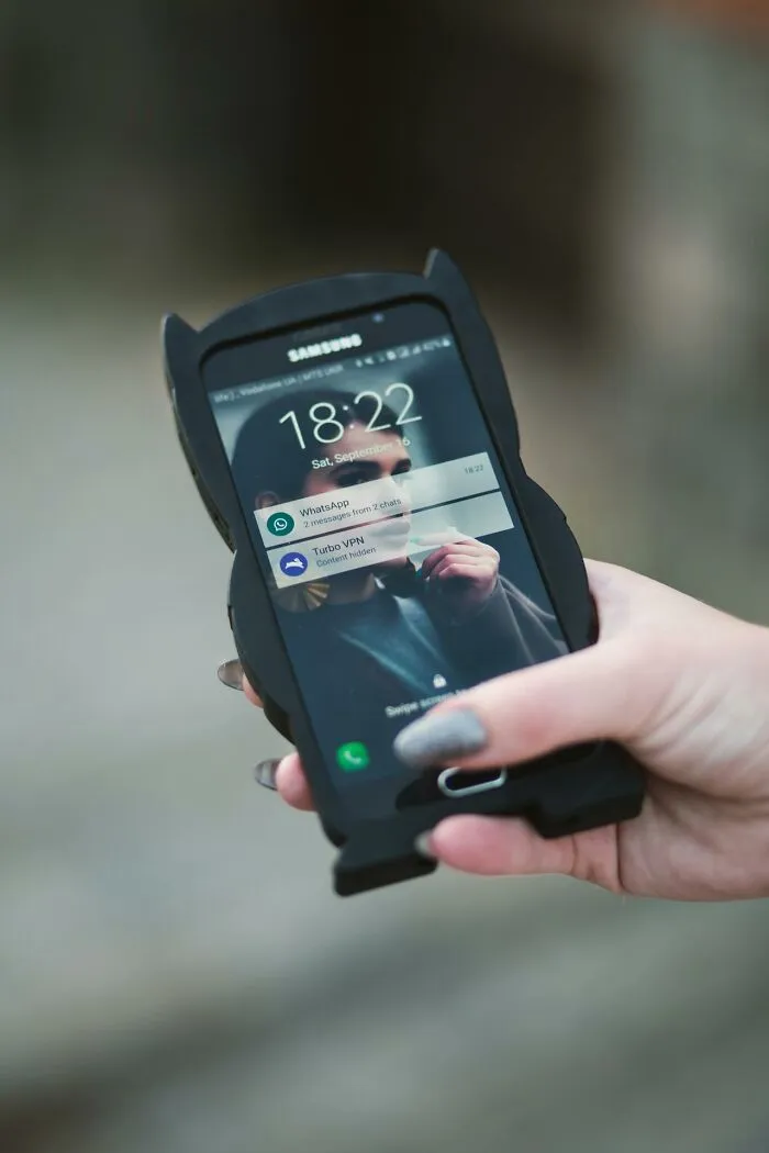 Hand holding a Samsung phone with notifications visible, illustrating silent judgment through digital behaviors.