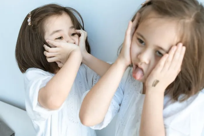 Two young girls making scared and confused faces, illustrating feelings often experienced by graveyard shift workers.