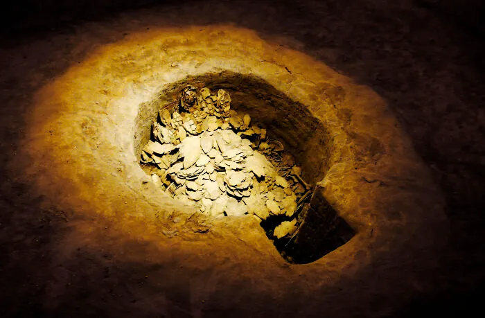 Ancient burial site illuminated, showcasing bones and artifacts linked to proven facts from historical stories and speculations.