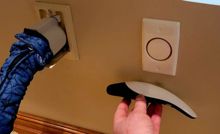 Hand holding unidentified object near wall outlet and device, illustrating internet solving mystery of unidentified objects.