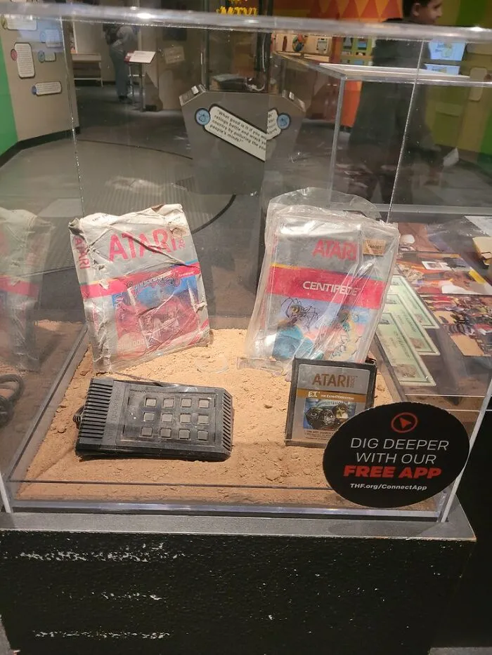 Vintage Atari game cartridges and console displayed in a glass case showcasing proven facts behind old gaming stories.