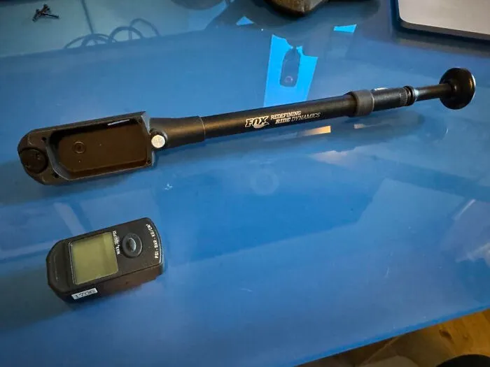 Bicycle shock pump and digital pressure gauge on blue surface, an example of solved unidentified objects online.