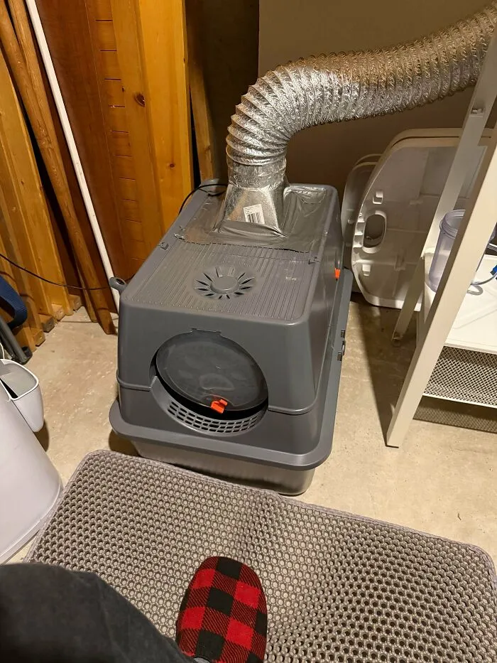 Improvised redneck engineering vent system attached to a cat litter box in a makeshift setup.
