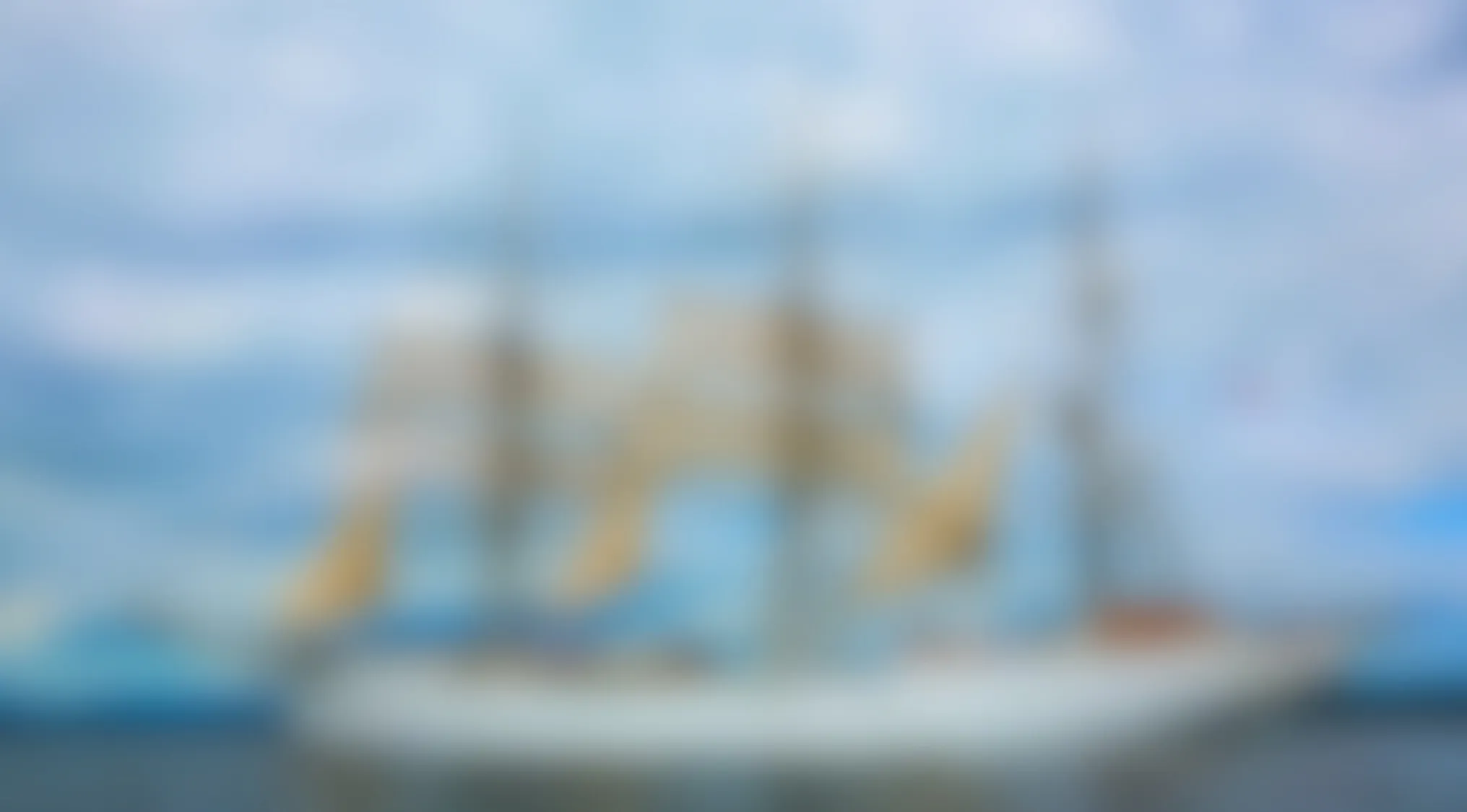 Blurry image of a sailing ship on the water with masts and sails barely visible behind the blur