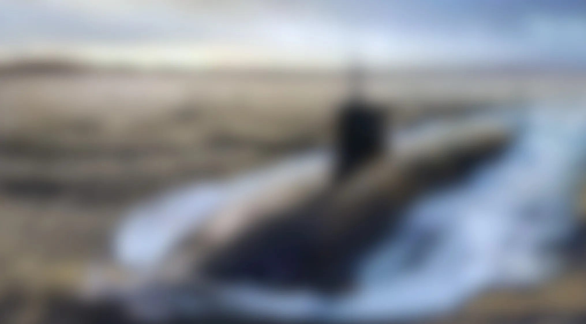 Blurry image showing a large vehicle moving through water with an unclear and indistinct shape.