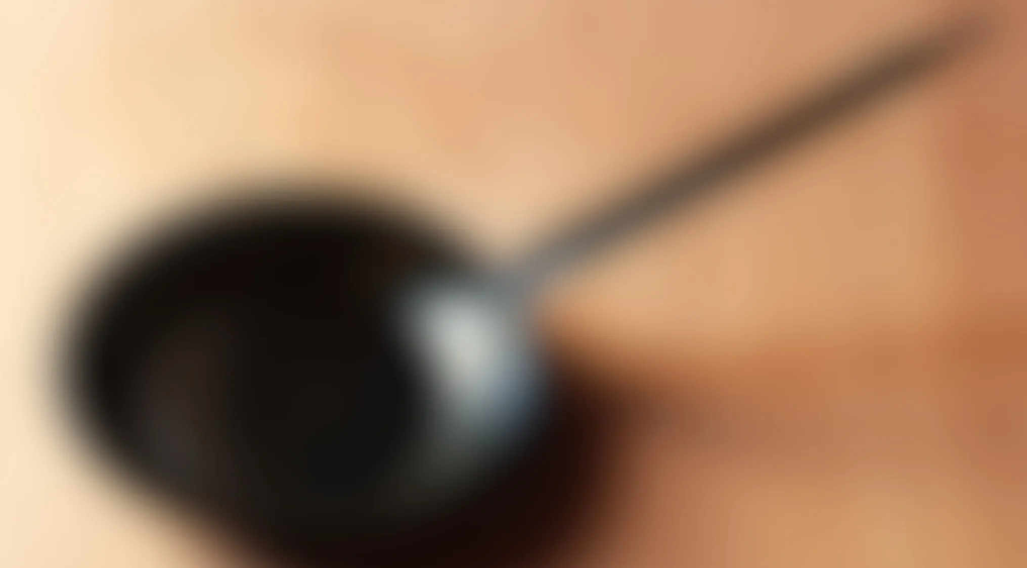 Blurry images showing an unclear but visible object resembling a pan or skillet on a wooden surface.