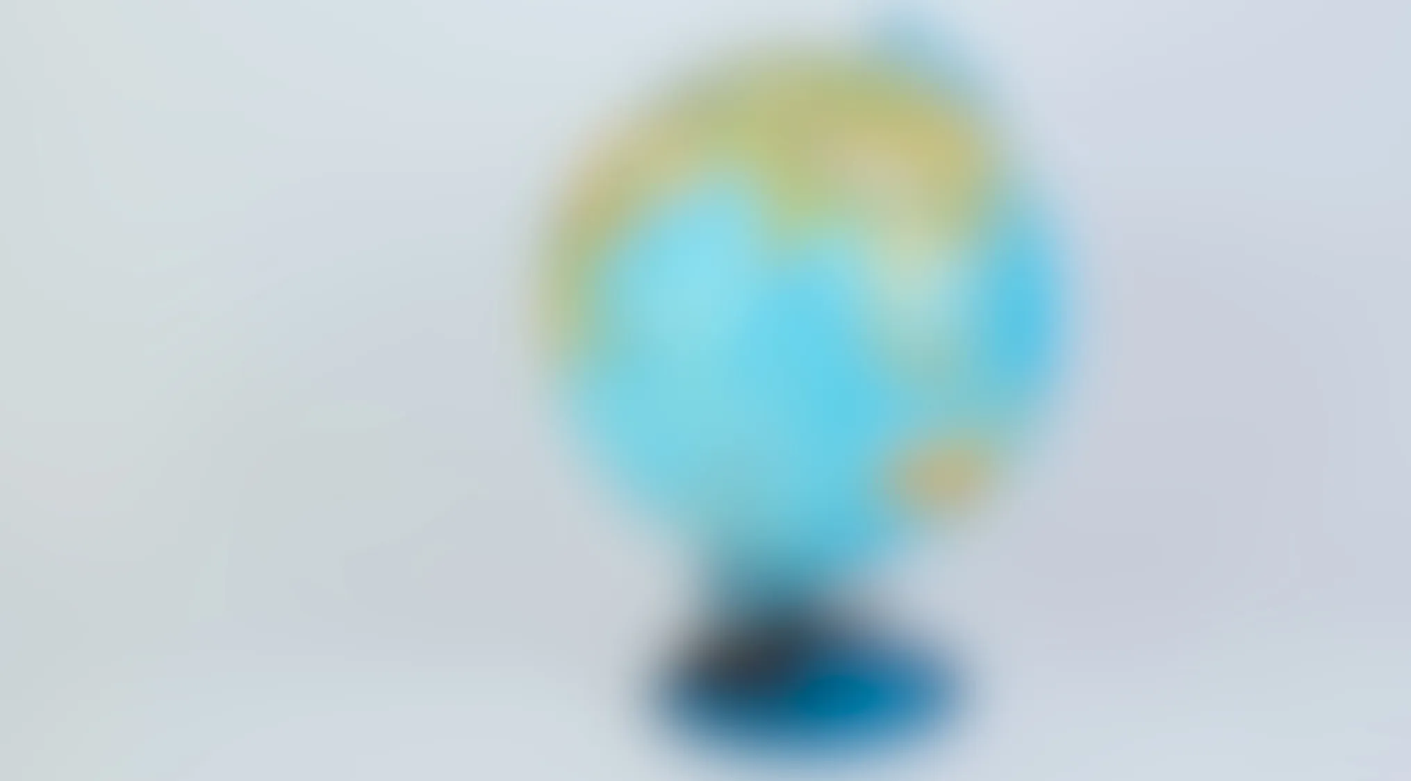 Blurry image of a globe on a stand with indistinct landmasses and oceans, subject unclear due to blur.